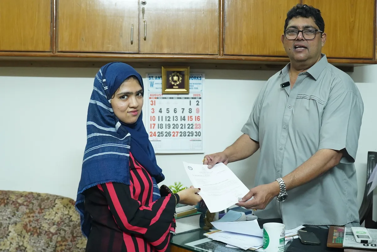 Handing over scholarship award grant document to student