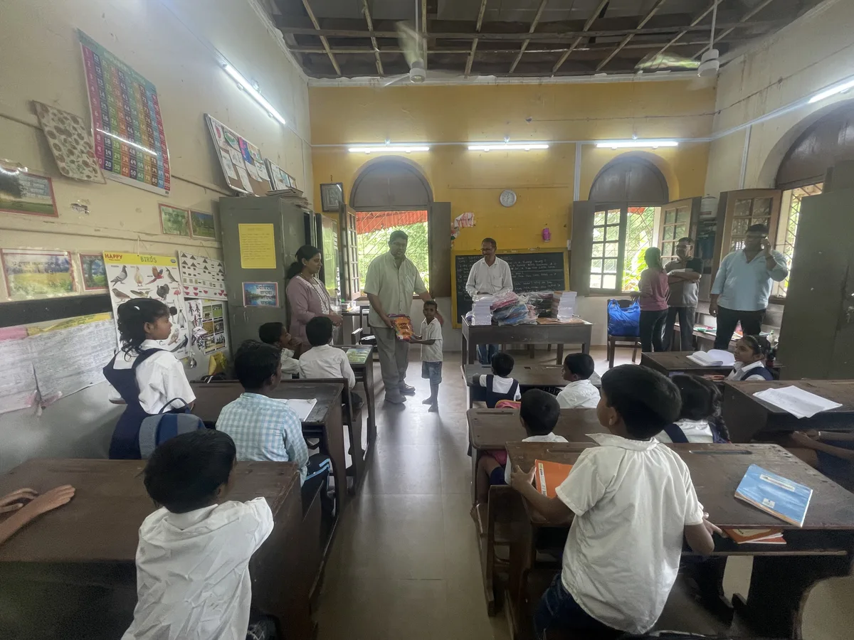 Distribution of free notebooks to students in village classroom